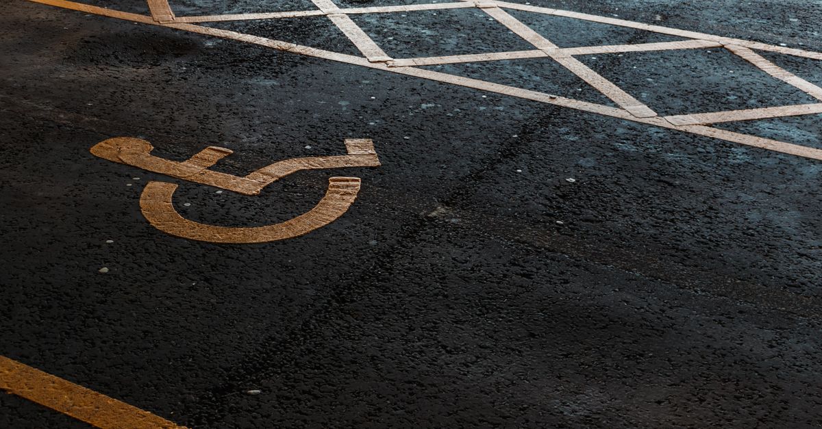 Disabled parking bay symbol painted on wet tarmac