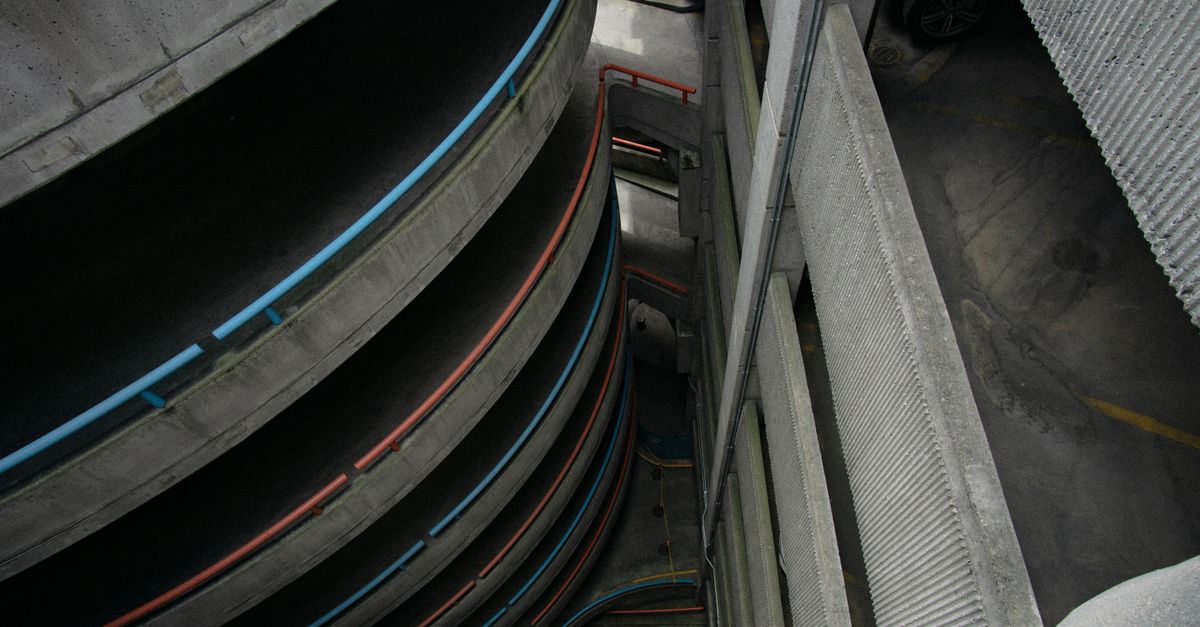 High-angle view inside a multi-storey car park showing ramps and rows of bays