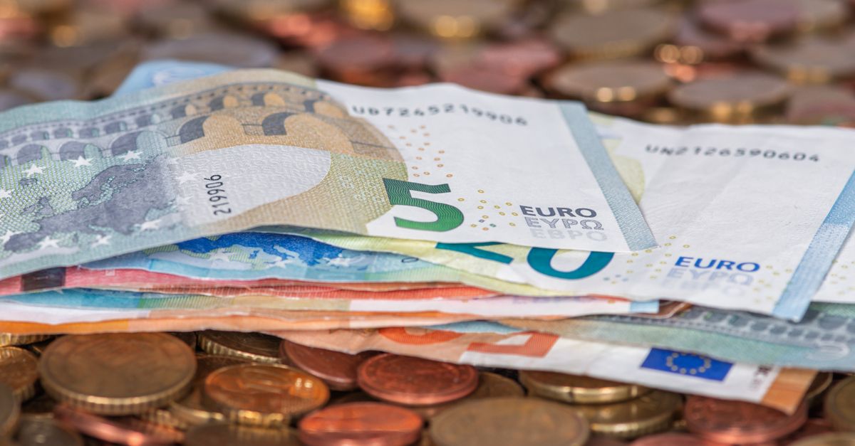 Euro banknotes and coins fanned out, representing foreign currency exchange