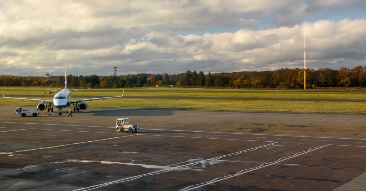 A passenger jet being towed across the airport apron