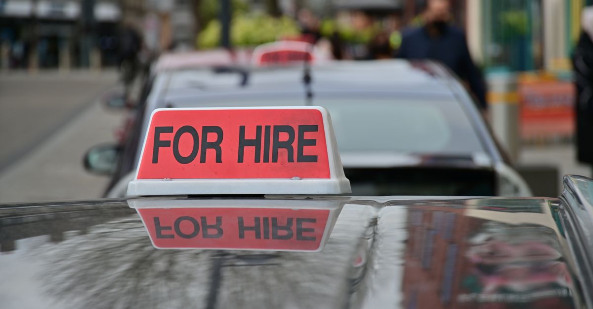 Red 'FOR HIRE' taxi roof sign on a car roof, with another cab queued ahead