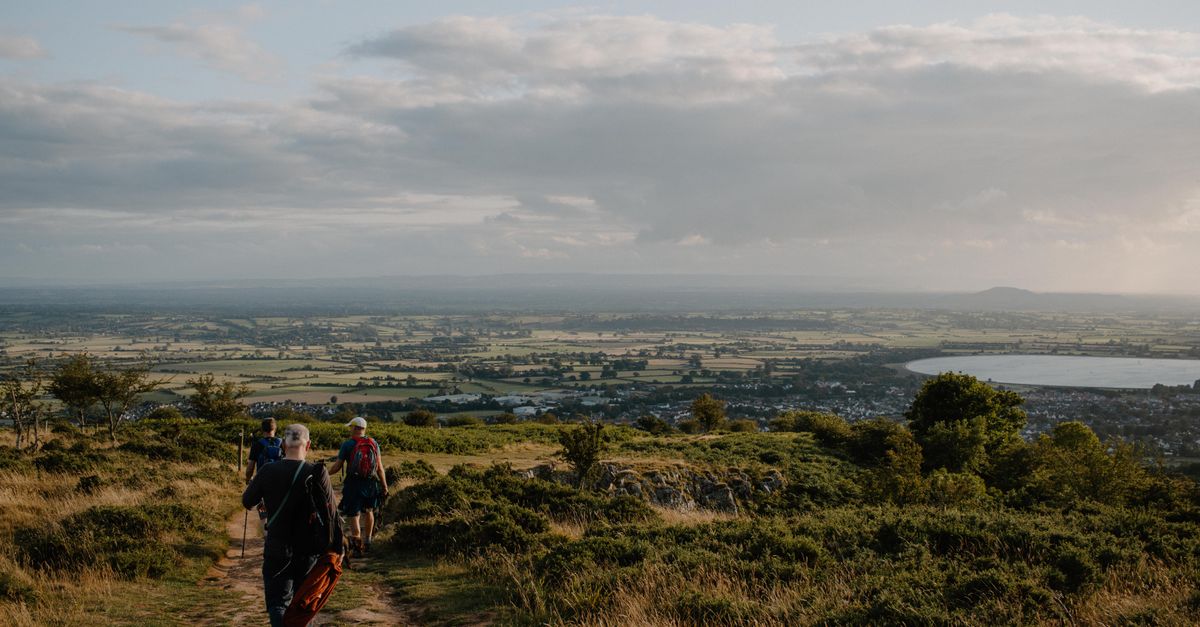 Hikers enjoy a scenic view over Cheddar, England during a summer day.