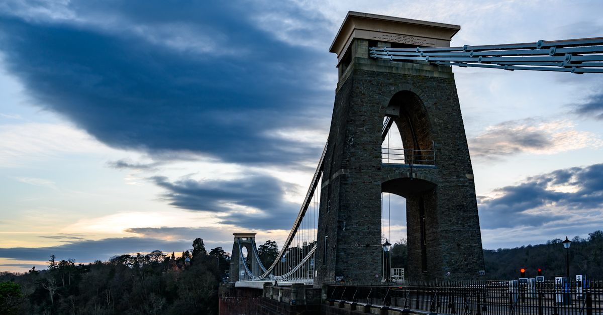 Iconic Clifton Suspension Bridge in Bristol, UK, photographed under a dramatic evening sky.