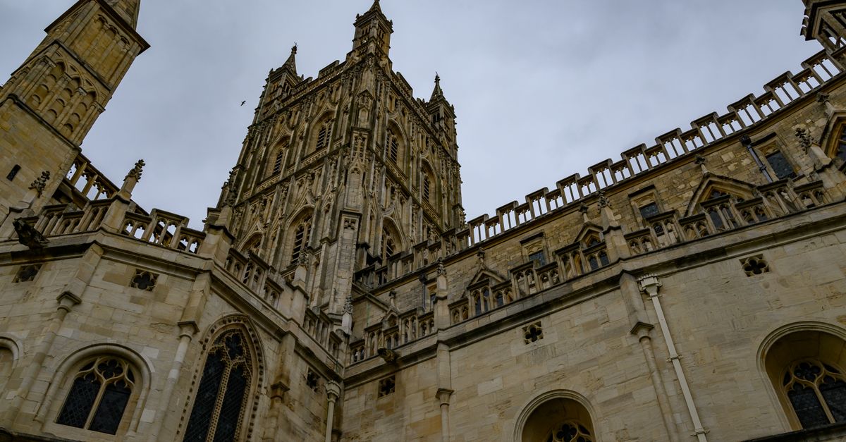Stunning Gothic view of Gloucester Cathedral in England under a cloudy sky.