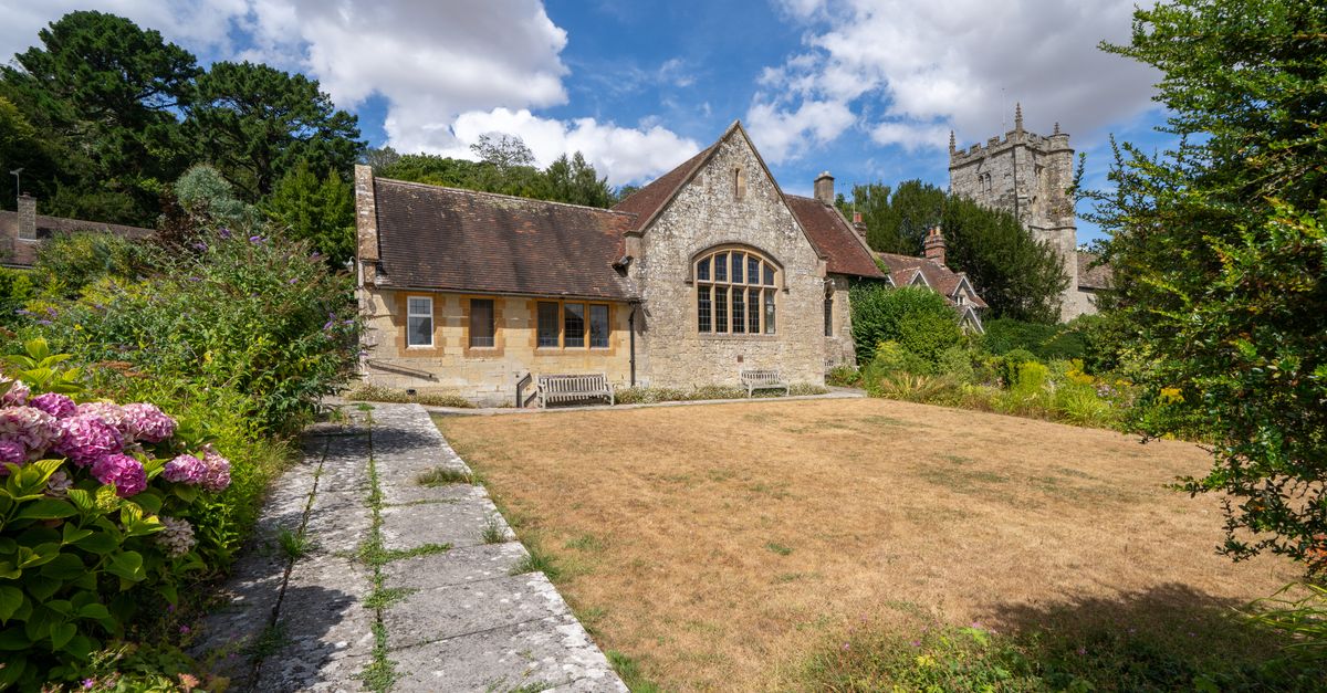 Charming historic building with garden in East Knoyle, England, under a bright summer sky.