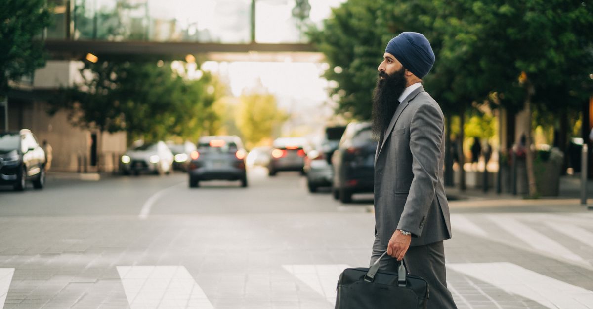 A professional traveller carrying a laptop bag crossing a city street