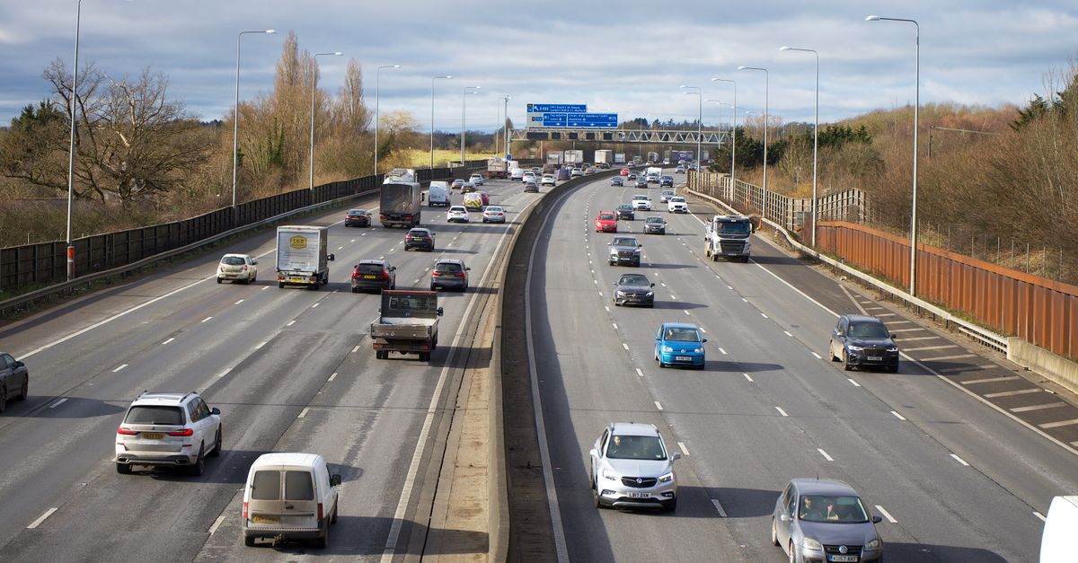 Aerial view of cars on a busy UK motorway, real number plates, daylight.