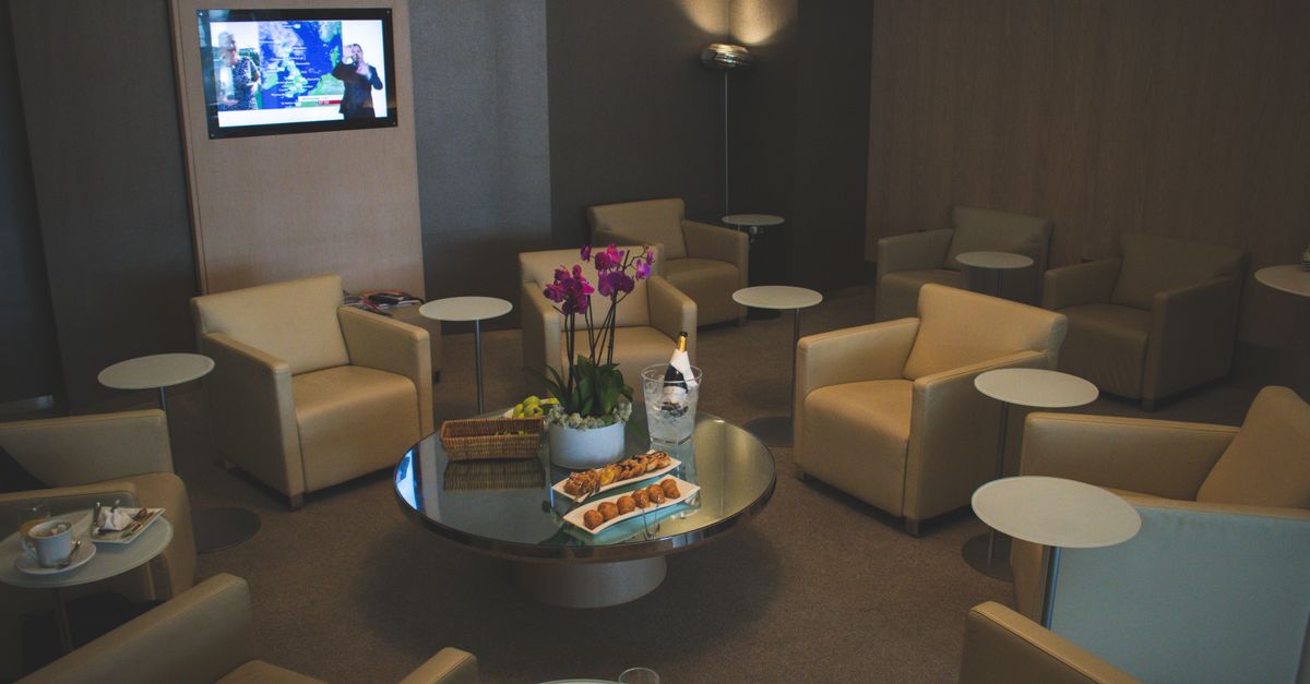 Comfortable lounge armchairs around a table with drinks and snacks laid out