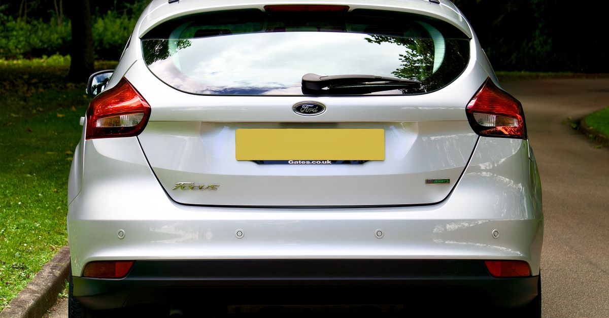 Rear view of an anonymous silver hatchback car, plate blanked, showing no operator branding